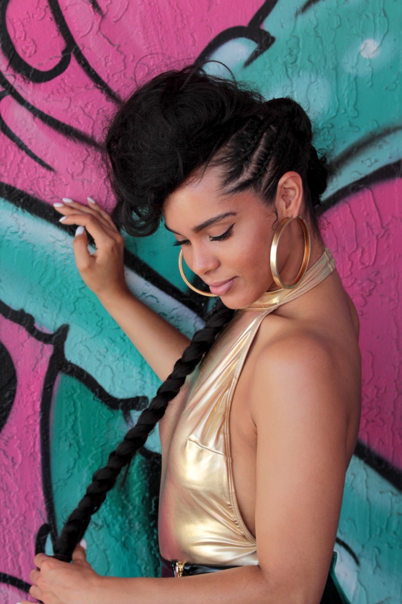 Braided updo with a single long knotless braid accent, styled by Hair by Alexy in Raleigh, NC